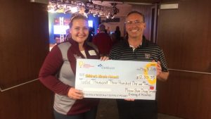 A dining services team member presenting a check to Children's Miracle Network.