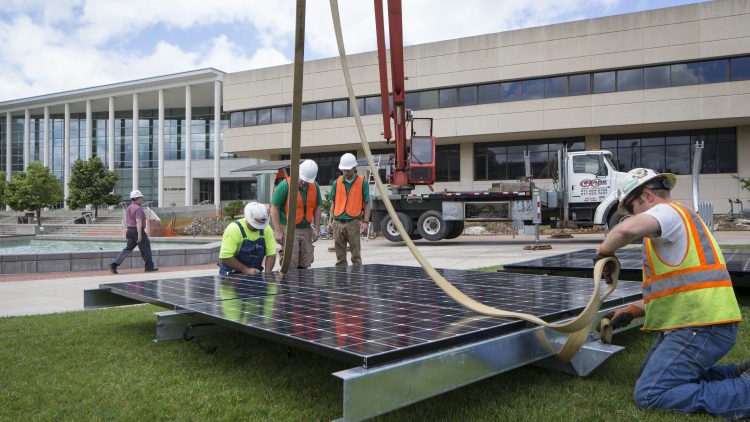 Construction workers installing solar panels. 