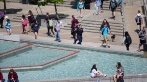 A campus scene of students sitting by the fountains.