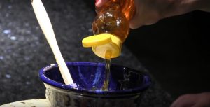 Natalie Allen pouring honey into a bowl.