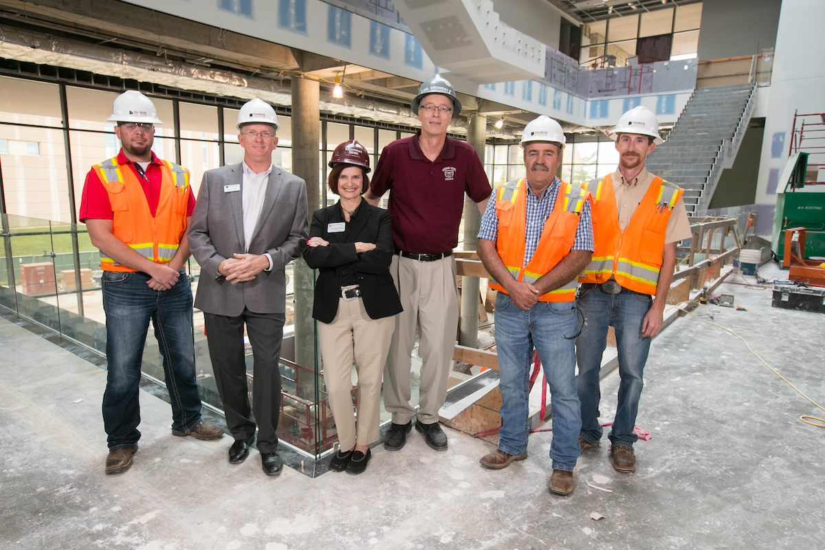 Stephanie Bryant, David Meinert and Dewitt Construction employees inside Glass Hall.