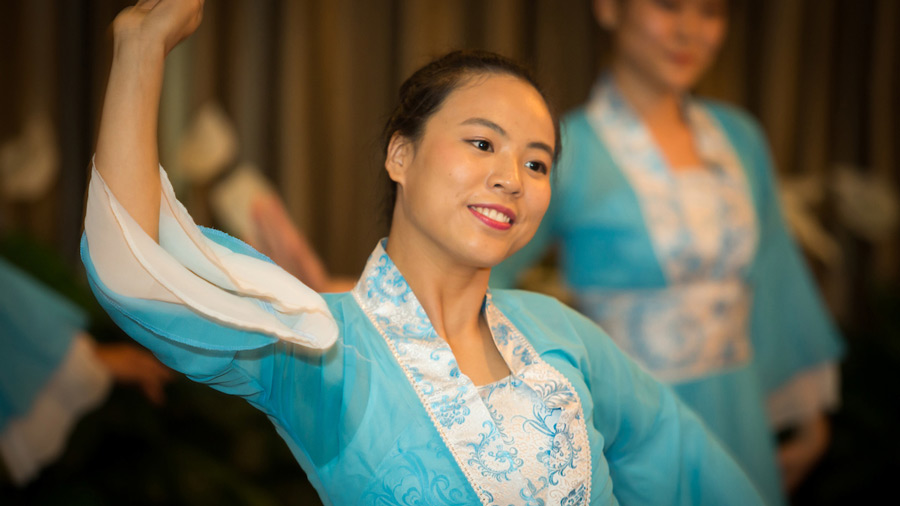An Asian-American student wearing a teal blue robe dances at Asia Fest 2017