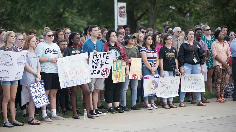 Students hold anti-racism signs at a protest
