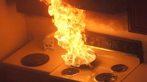 A pan on a stove on fire.
