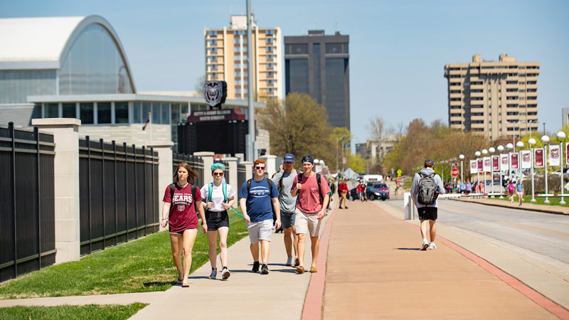 Students walk to class on a sunny spring day on campus.