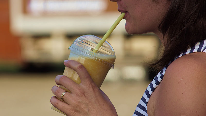 A woman drinks a smoothie after a workout.
