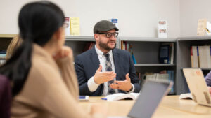 Professor talking with students around a table