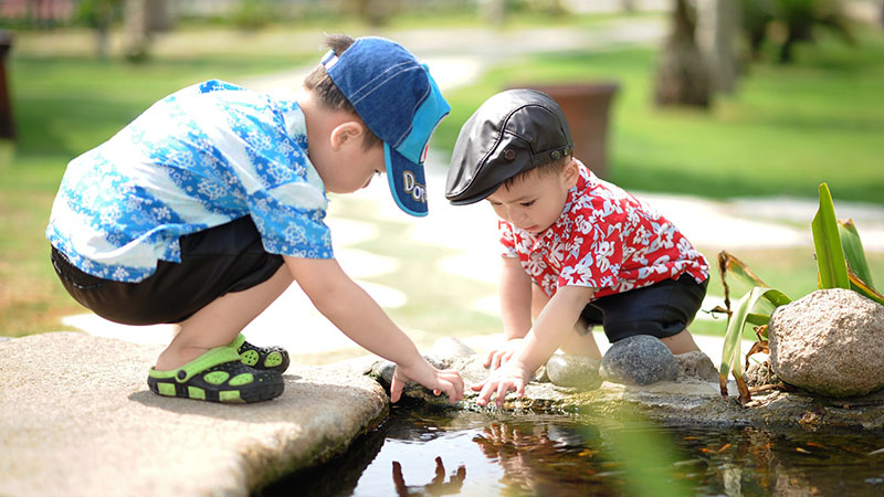Two young children playing together outdoors.