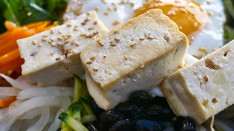 A plate of tofu and assortment of vegetables.