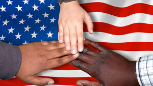 Three different colored hands on an American flag.