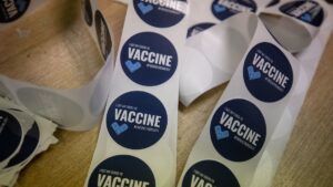 A roll of blue stickers that say "I got my COVID-19 vaccine. #FinishStrong417."
