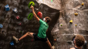 Student climbs rock wall in Foster Recreation Center.Student climbs rock wall in Foster Recreation Center.