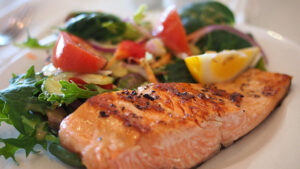 A plate of salmon with salad.