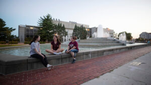 Students relax by the John Q. Hammons Fountains on campus.