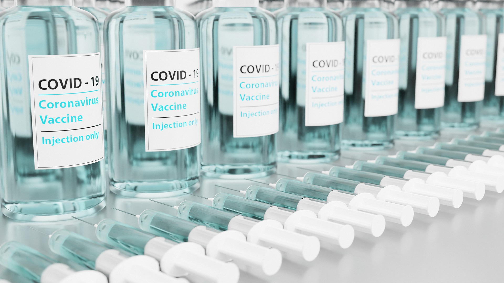 Bottles of COVID-19 vaccines and syringes.