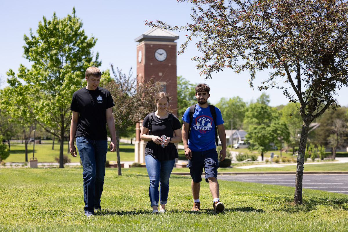 Three students walk across West Plains' campus grounds.