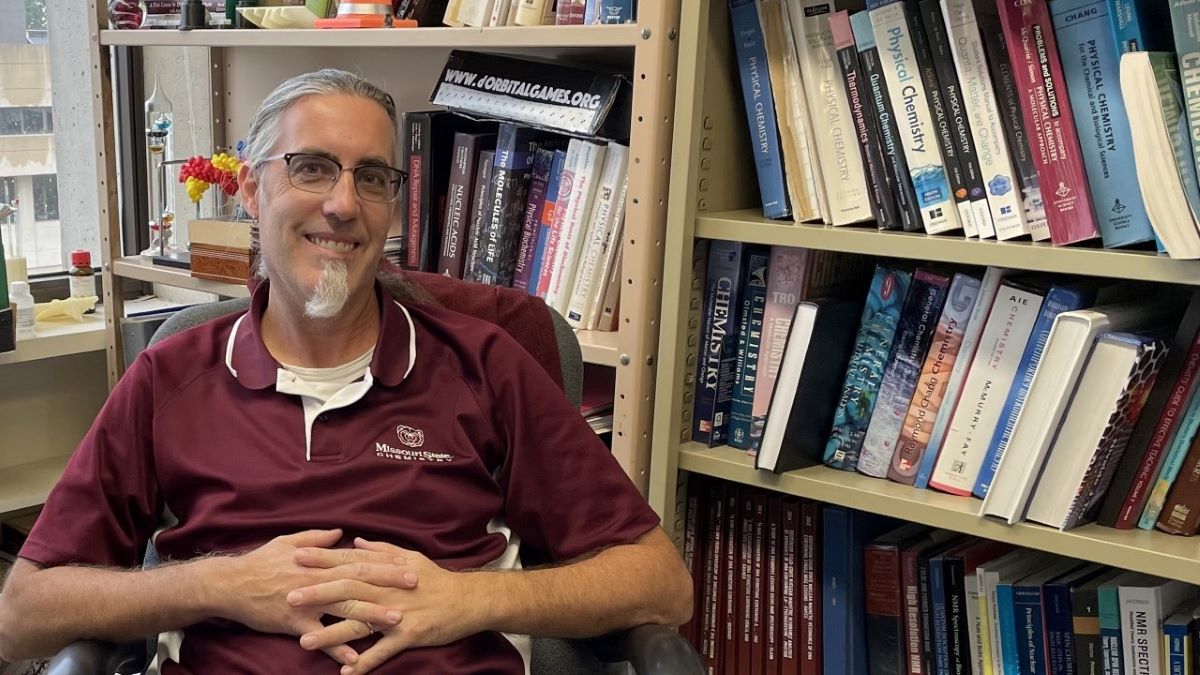 Dr. Gary Meints sits in his office surrounded by chemistry books as learning material.