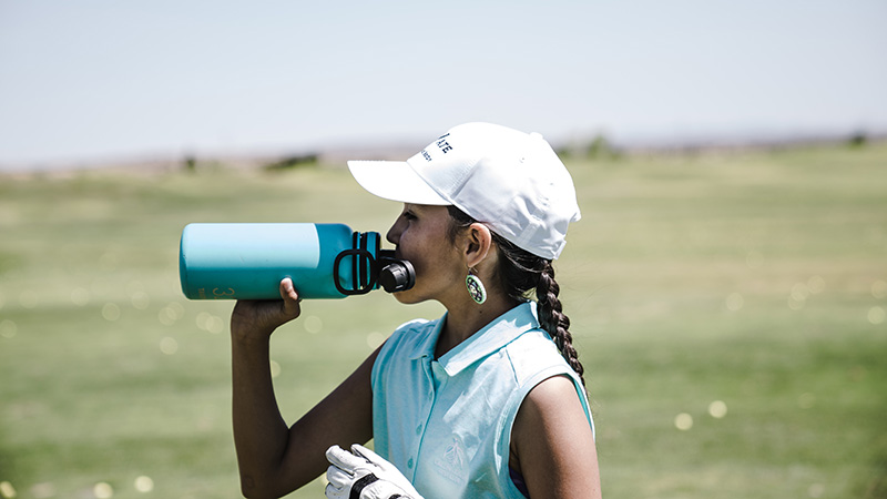 An athlete taking a drink from a sports bottle.