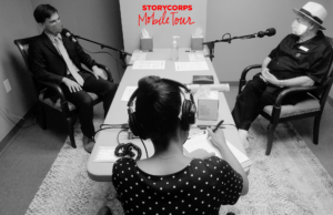 Three masked individuals sit in recording studio.