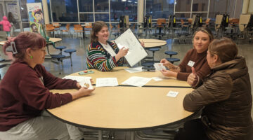 MSU students and an ELL work together around the table.