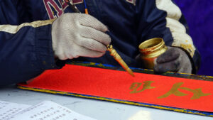 A person writing Chinese calligraphy.