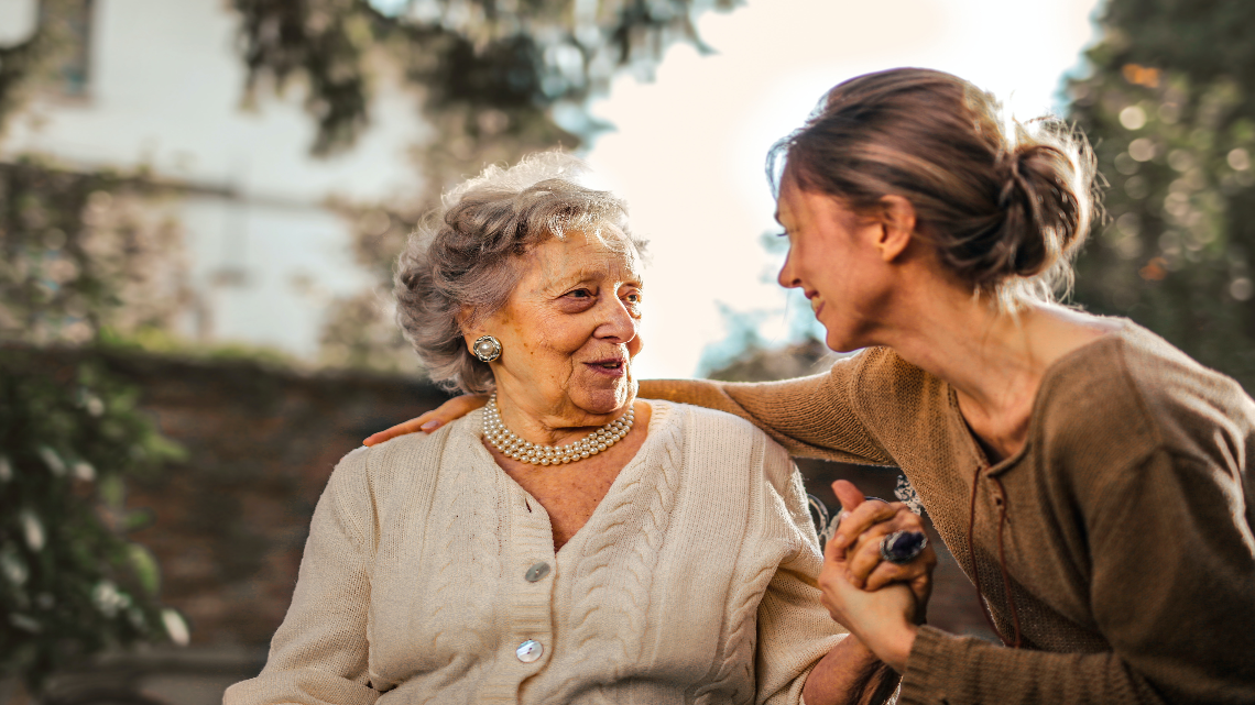 A woman and an elderly woman look at each other