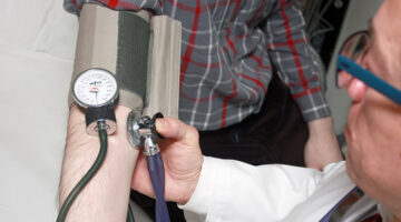 A doctor taking the blood pressure of a patient.