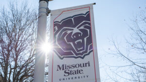 The sun shining on a Bear head logo banner.