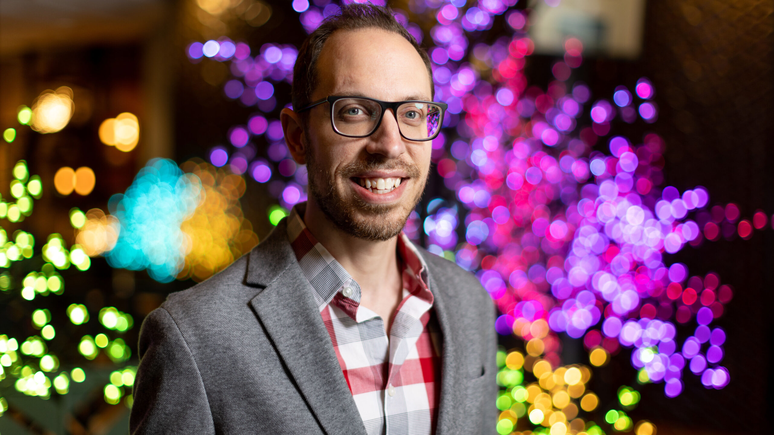 Dr. Josh Coleman in front of Christmas lights