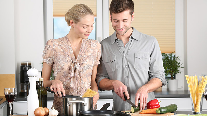 A woman and man preparing food together.