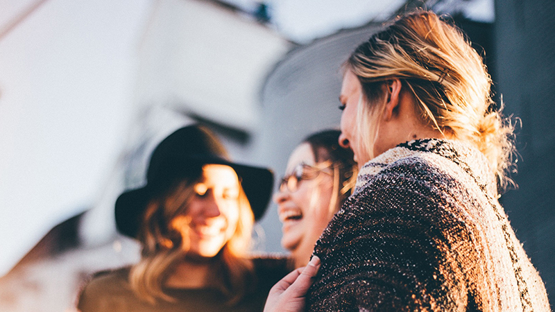 Three women smiling and laughing.