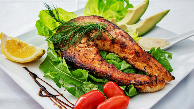 A colorful plate of food - fish and vegetables.