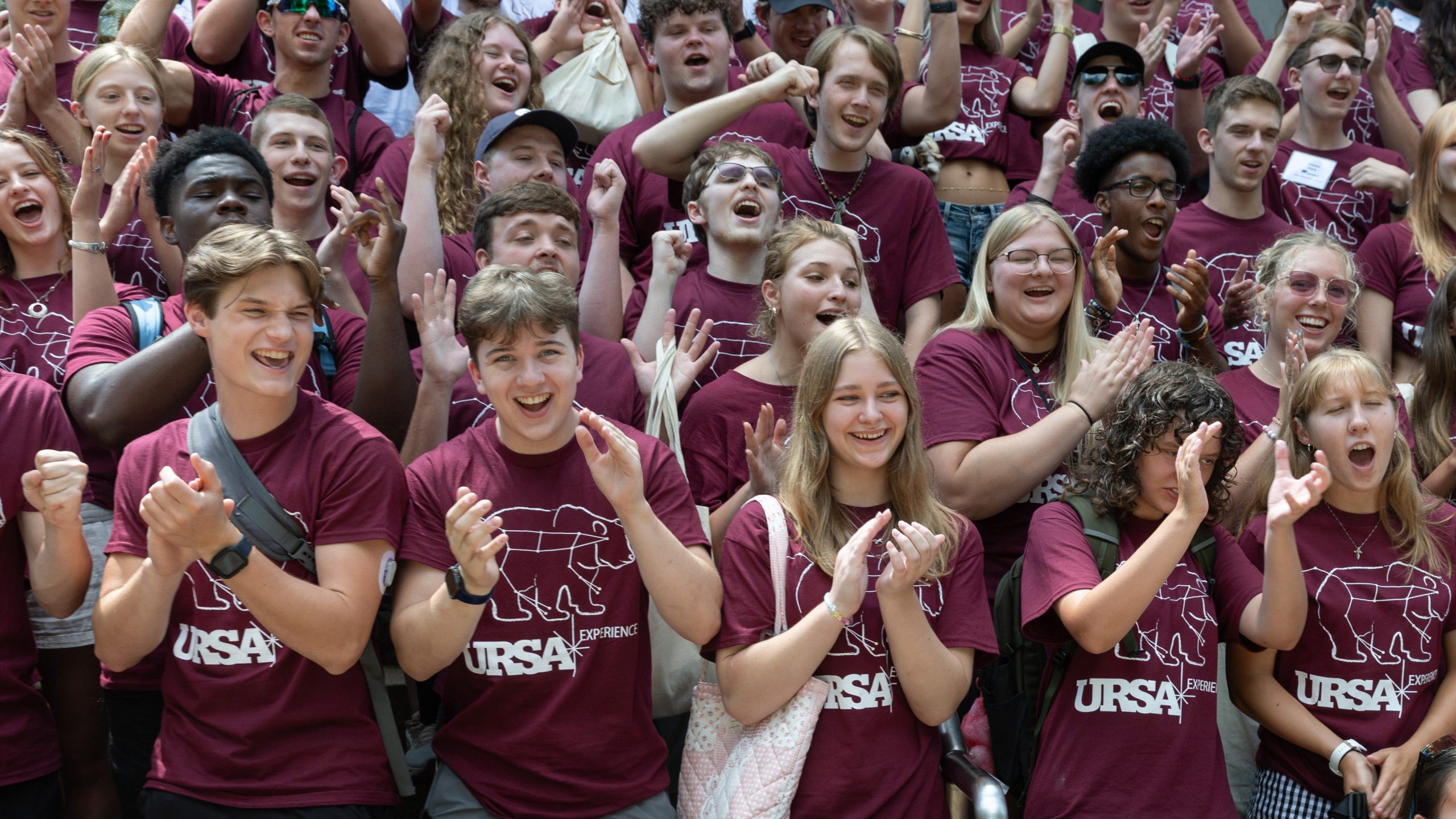 Students in maroon URSA shirts cheer