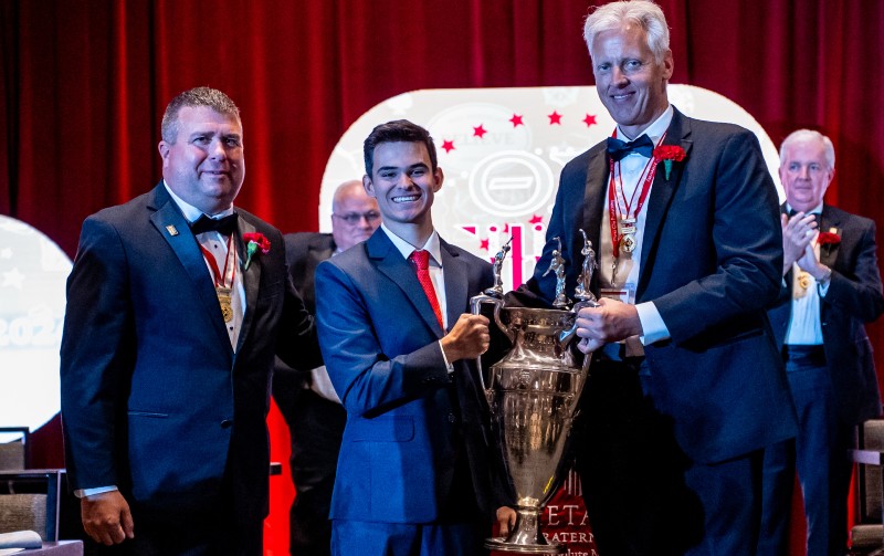 Missouri State University student Carlos Abrams (center) receives the Colley trophy from Tom Thompson, who serves on Theta Chi Fraternity's international board of directors (right) and Theta Chi Fraternity CEO Mike Mayer (left).