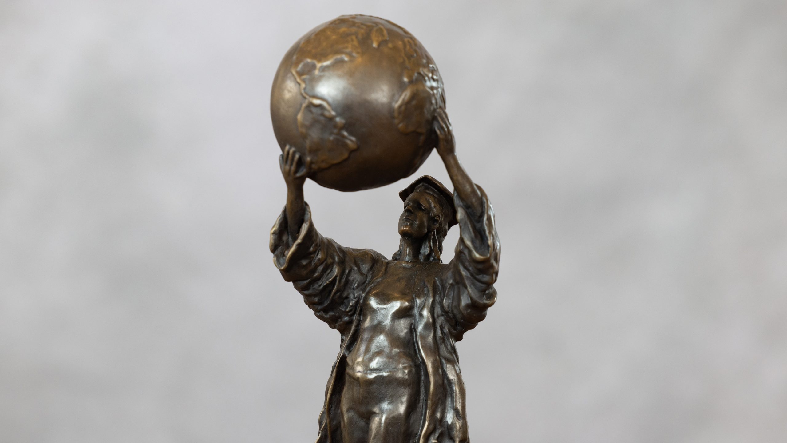 A bronze statue of a woman holding the globe
